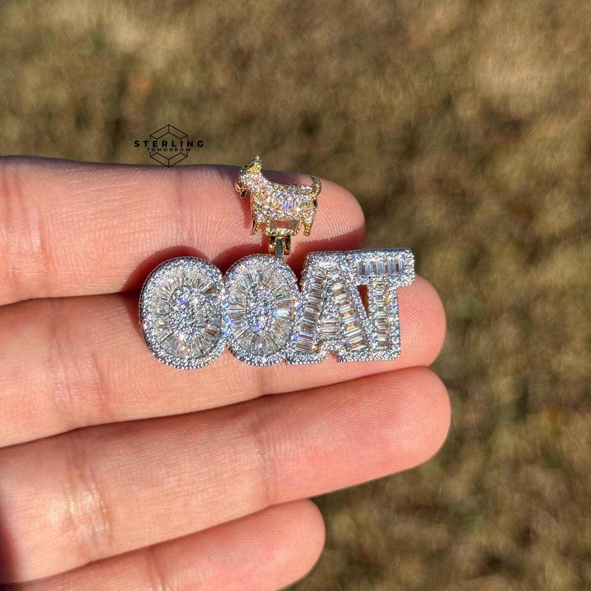 iced out goat pendant held outside in natural sunlight